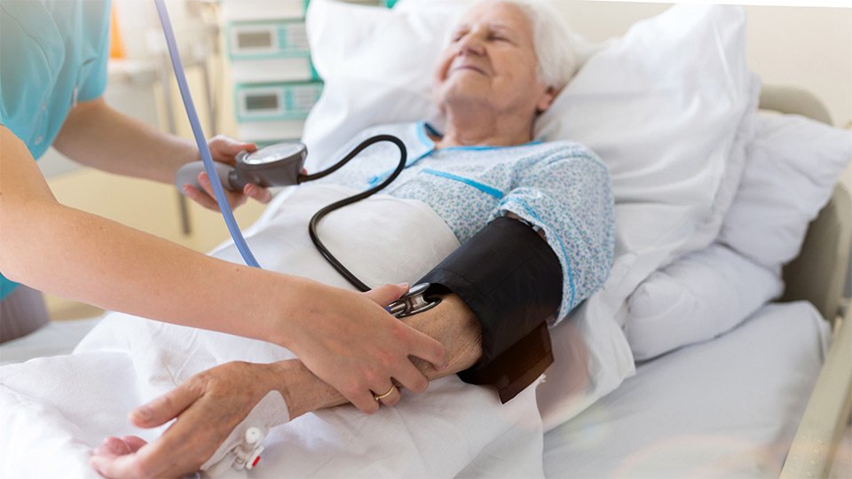 Patientin mit Schmerzen: Behandlungssituation im Krankenhaus.